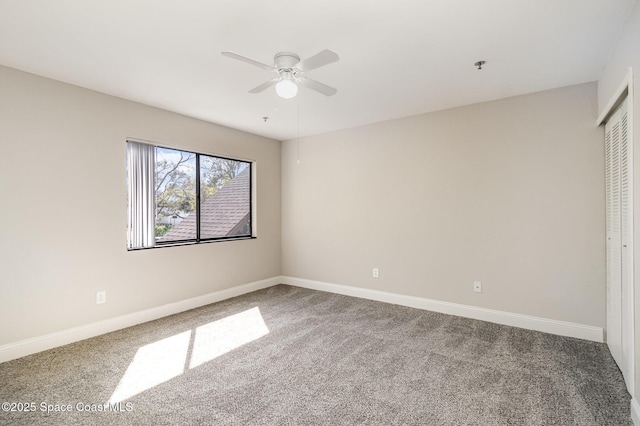 carpeted spare room with baseboards and ceiling fan