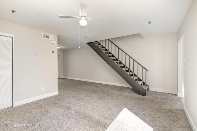 unfurnished living room featuring stairway, carpet flooring, a ceiling fan, and baseboards