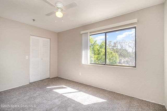 unfurnished bedroom with carpet flooring, a ceiling fan, and a closet