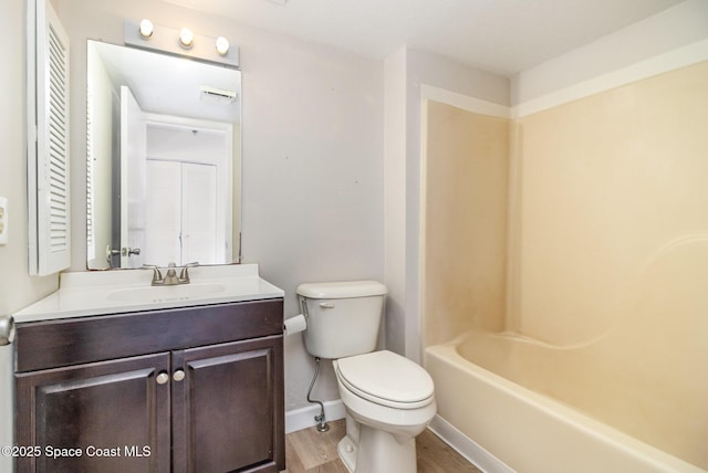 full bath with baseboards, toilet, wood finished floors, and vanity