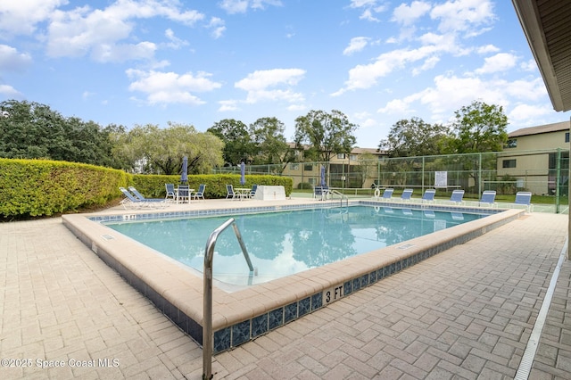 community pool featuring a patio and fence