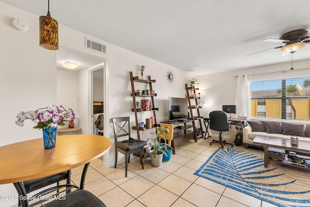 living area featuring light tile patterned floors, visible vents, and a ceiling fan