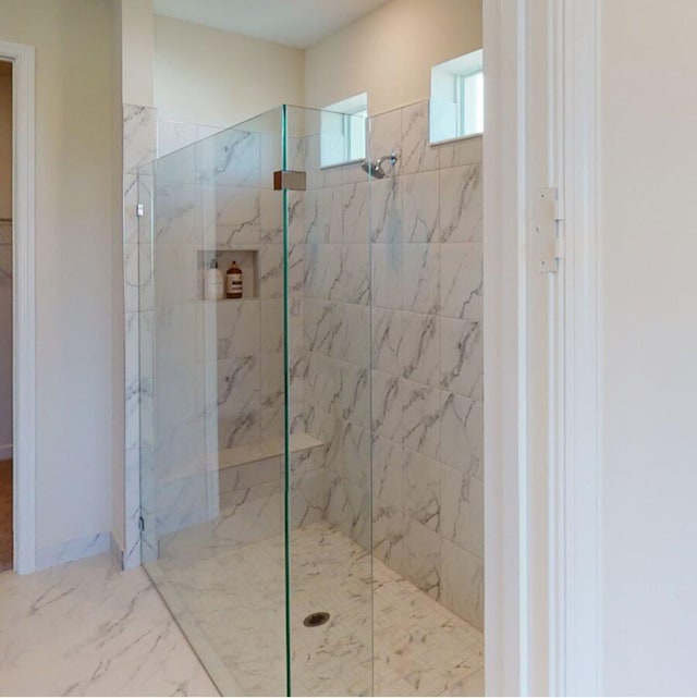 full bathroom with baseboards, marble finish floor, and a marble finish shower