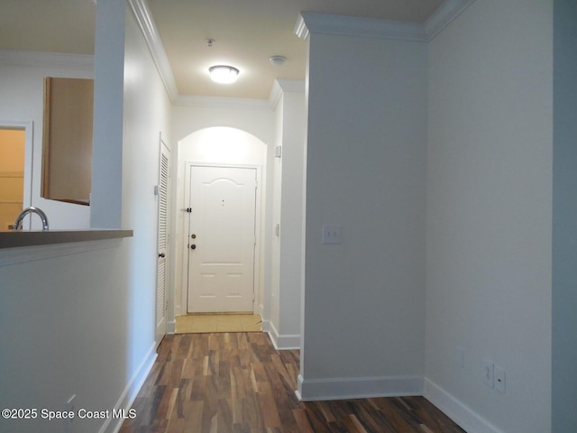 hall featuring crown molding, wood finished floors, and baseboards