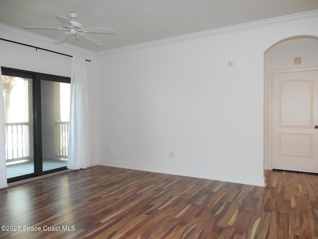 unfurnished room featuring ceiling fan, arched walkways, ornamental molding, and dark wood finished floors