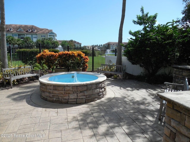 view of pool featuring an outdoor hot tub, a fenced backyard, and a patio area