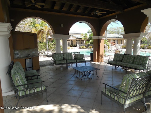 view of patio featuring a sink, a community pool, ceiling fan, and outdoor lounge area