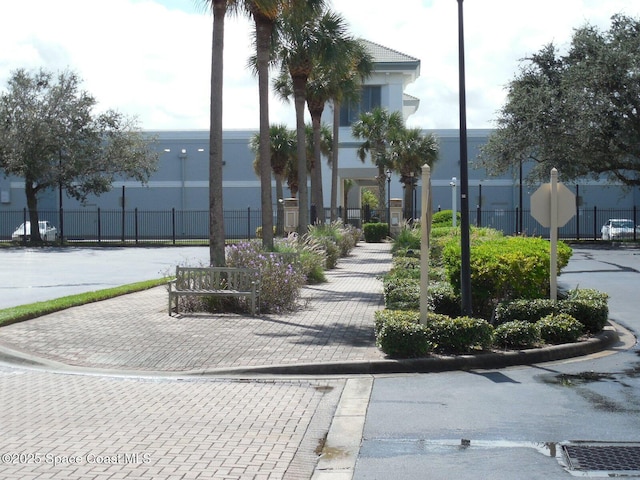 surrounding community featuring decorative driveway and fence