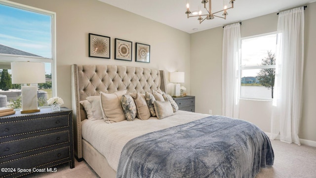 bedroom with an inviting chandelier, baseboards, and carpet floors