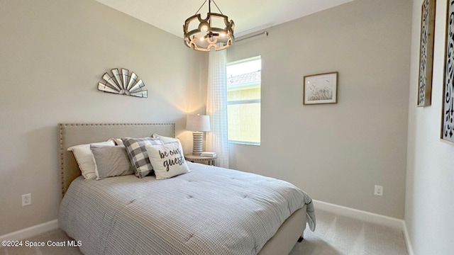 carpeted bedroom with a notable chandelier and baseboards