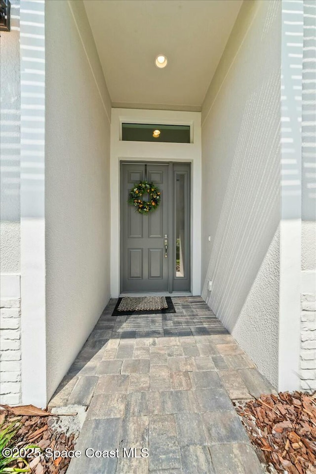 property entrance with stucco siding