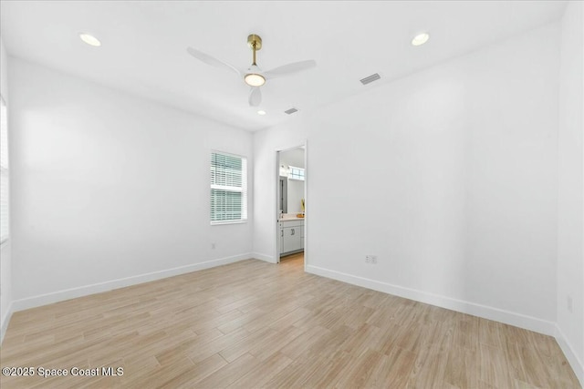 unfurnished room featuring baseboards, visible vents, and light wood-style flooring