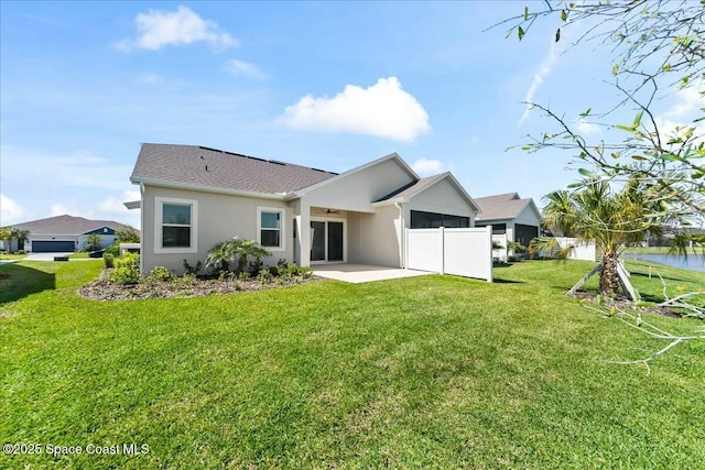 back of house featuring stucco siding, a yard, a patio, and ceiling fan