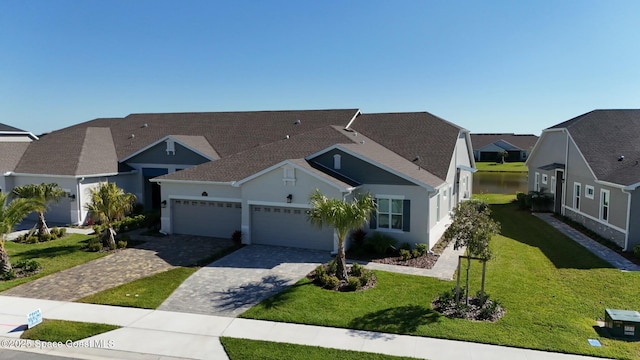 view of front of house with a residential view, a front lawn, an attached garage, stucco siding, and decorative driveway