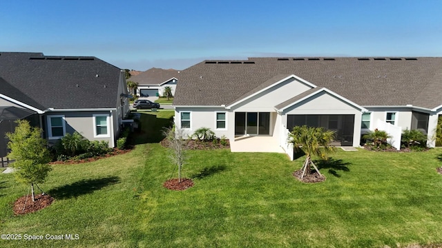back of house with a lawn, a shingled roof, and stucco siding