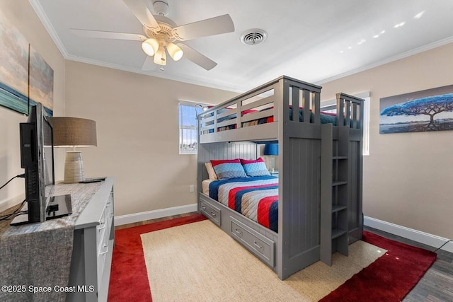 bedroom with visible vents, wood finished floors, crown molding, baseboards, and ceiling fan