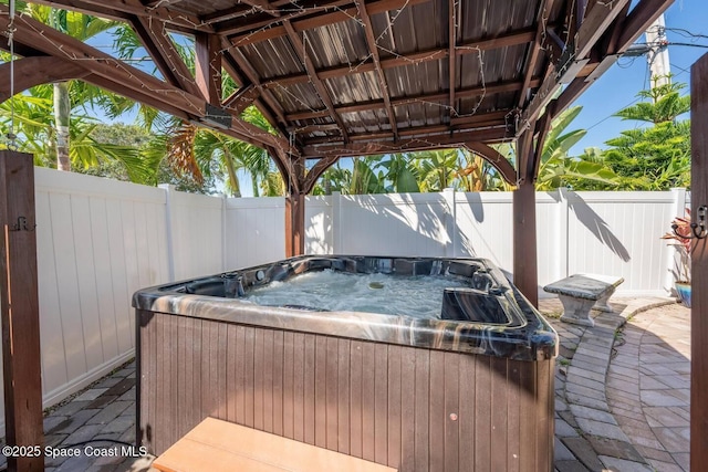 view of patio / terrace featuring a hot tub and a fenced backyard