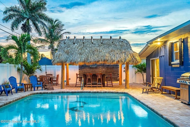 view of swimming pool featuring a patio area, a fenced in pool, a fenced backyard, and outdoor dry bar