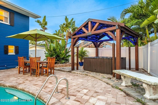 view of patio / terrace featuring a gazebo, a jacuzzi, a fenced backyard, and outdoor dining space