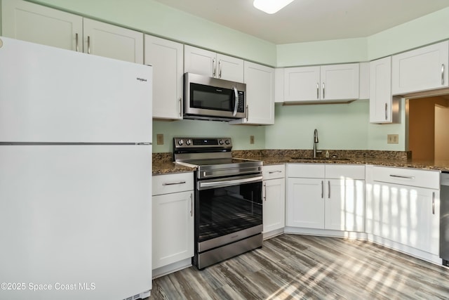 kitchen featuring white cabinets, light wood-style floors, appliances with stainless steel finishes, and a sink