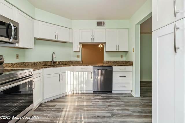 kitchen with a sink, visible vents, appliances with stainless steel finishes, and white cabinets