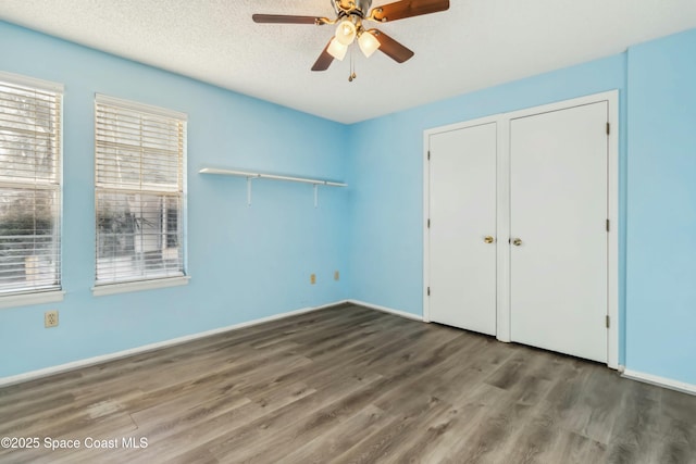 unfurnished bedroom featuring ceiling fan, baseboards, a textured ceiling, and wood finished floors