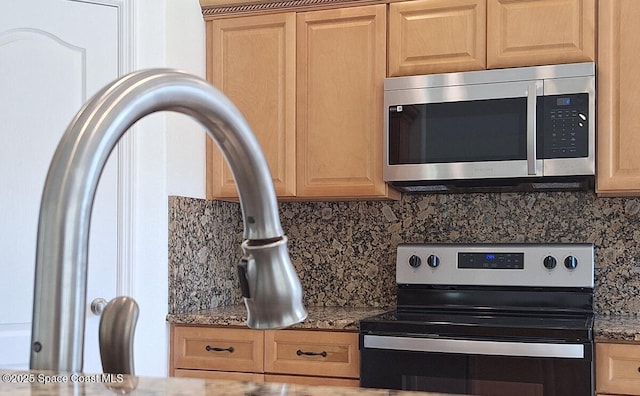 interior details with backsplash, light brown cabinets, stainless steel appliances, and dark stone countertops