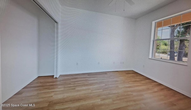 spare room featuring wood finished floors and baseboards