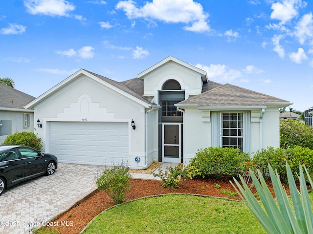 4942 Worthington Cir, Rockledge, FL 32955 - view of front of property with a garage, stucco siding, decorative driveway, and a shingled roof