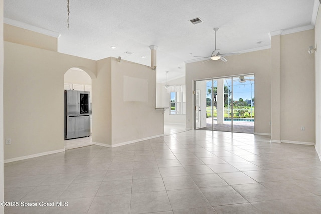 4942 Worthington Cir, Rockledge, FL 32955 - unfurnished room with a ceiling fan, crown molding, light tile patterned flooring, a textured ceiling, and arched walkways