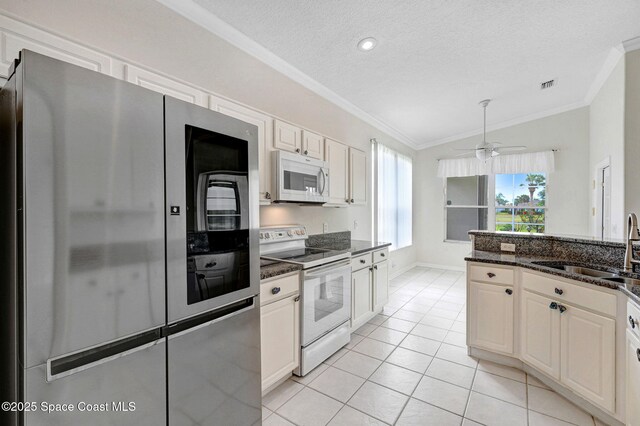 4942 Worthington Cir, Rockledge, FL 32955 - kitchen with white appliances, crown molding, a textured ceiling, light tile patterned floors, and lofted ceiling
