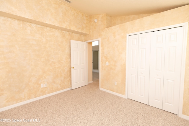 unfurnished bedroom featuring carpet flooring, baseboards, and a closet