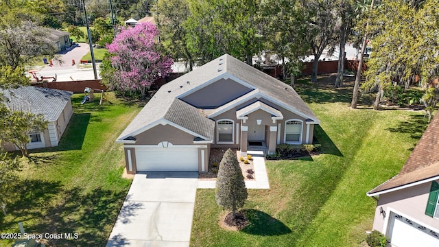 view of front of house with a shingled roof, a front lawn, concrete driveway, stucco siding, and a garage