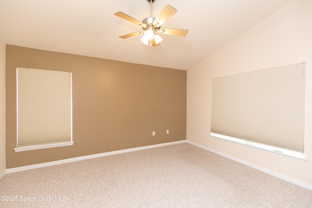 carpeted empty room with baseboards, ceiling fan, and vaulted ceiling