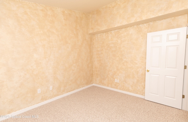 empty room featuring baseboards and carpet floors