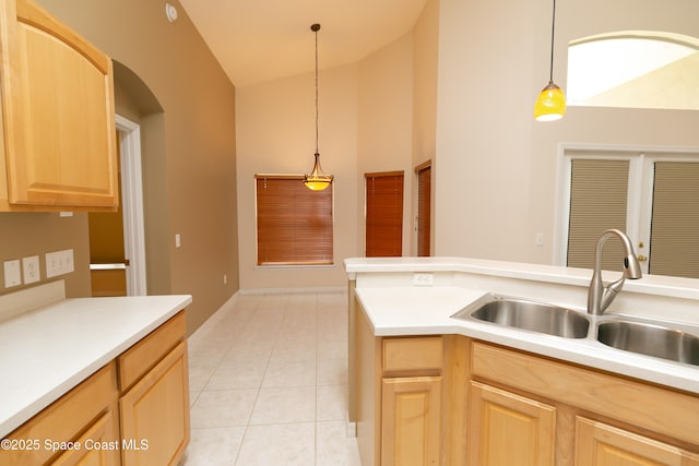 kitchen featuring light brown cabinets, pendant lighting, light countertops, light tile patterned flooring, and a sink