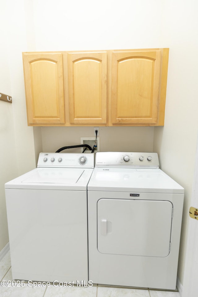 washroom with washer and clothes dryer and cabinet space