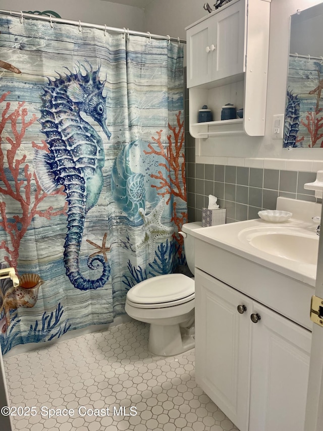 full bathroom featuring vanity, tile walls, toilet, and a shower with shower curtain