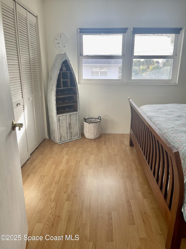 bedroom with light wood-style flooring and a closet