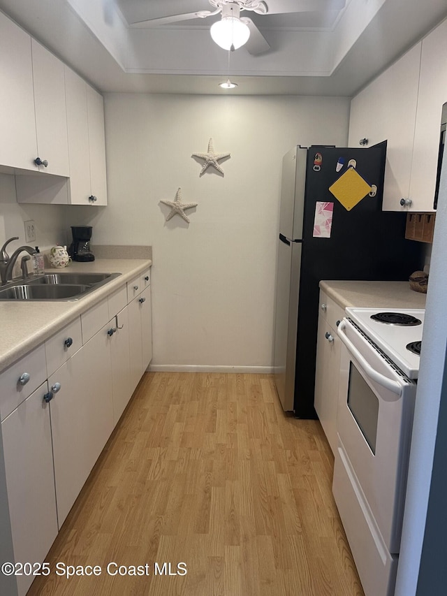 kitchen featuring white range with electric stovetop, white cabinetry, light wood-style floors, and a sink