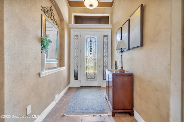 entrance foyer with baseboards and a textured wall