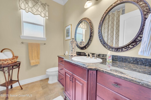 bathroom with baseboards, toilet, and vanity