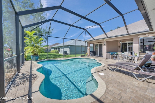 pool with glass enclosure, a patio, and ceiling fan