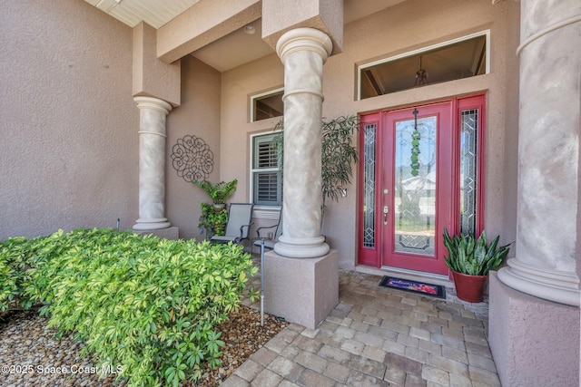 entrance to property featuring stucco siding and a porch