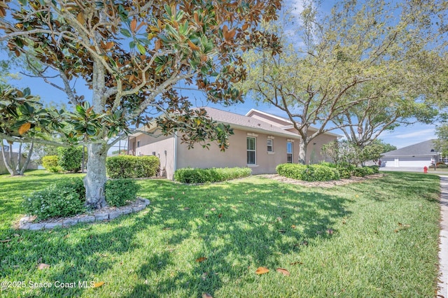 exterior space with stucco siding and a front lawn