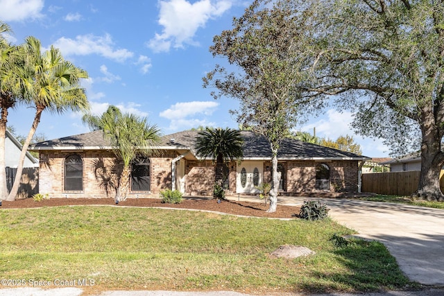 ranch-style home with brick siding, driveway, a front yard, and fence