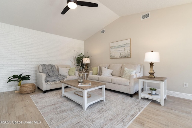 living room featuring visible vents, light wood-style flooring, a ceiling fan, and vaulted ceiling