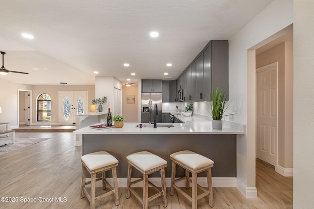 kitchen featuring a sink, light wood-style flooring, gray cabinets, and light countertops