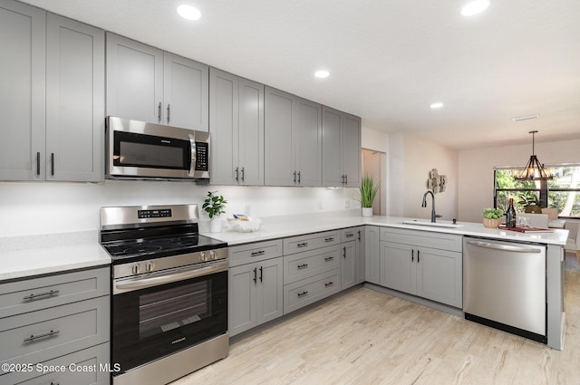 kitchen featuring a sink, stainless steel appliances, gray cabinets, and light countertops