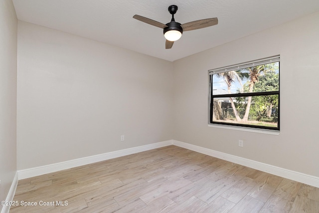 spare room with light wood-style flooring, a ceiling fan, and baseboards